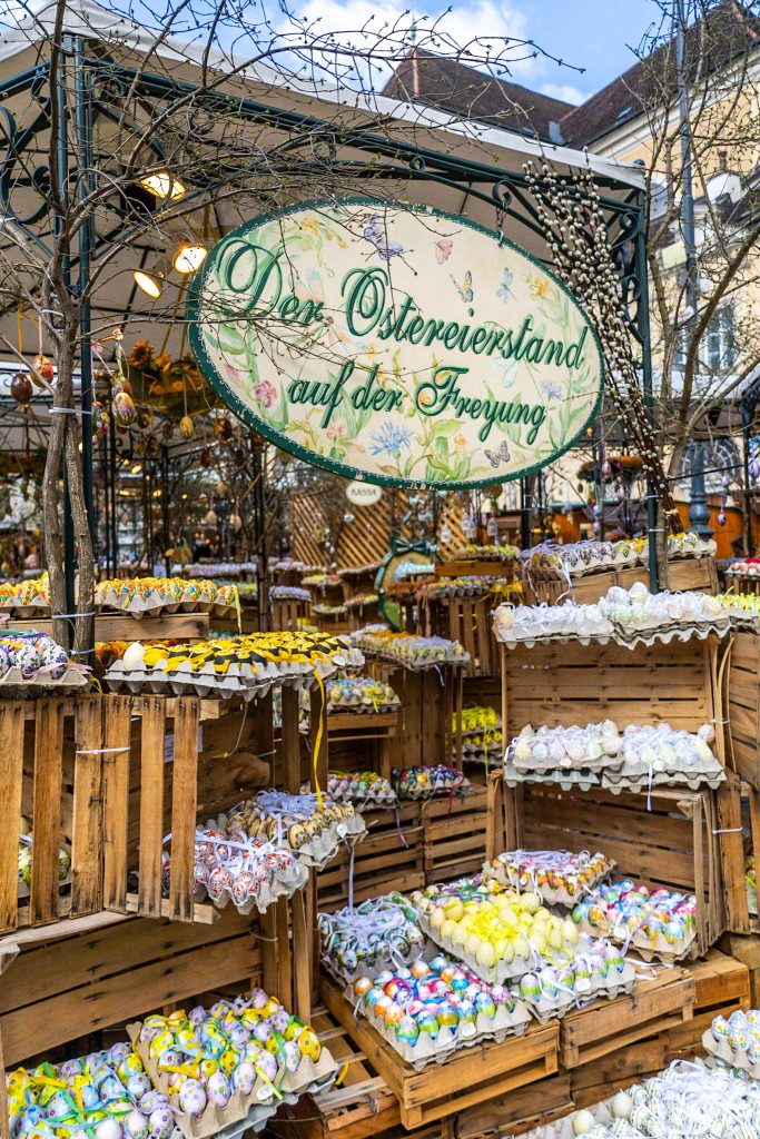 Ostereierstand auf dem Ostermarkt auf der Freyung in Wien mit bunten bemalten Ostereiern in Holzkisten.