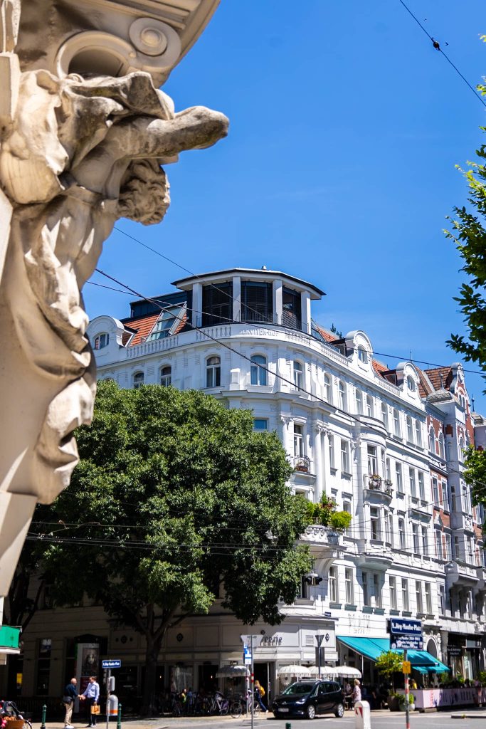 weißes Haus im Servitenviertel in Wien, im Vordergrund Steinfigur.
