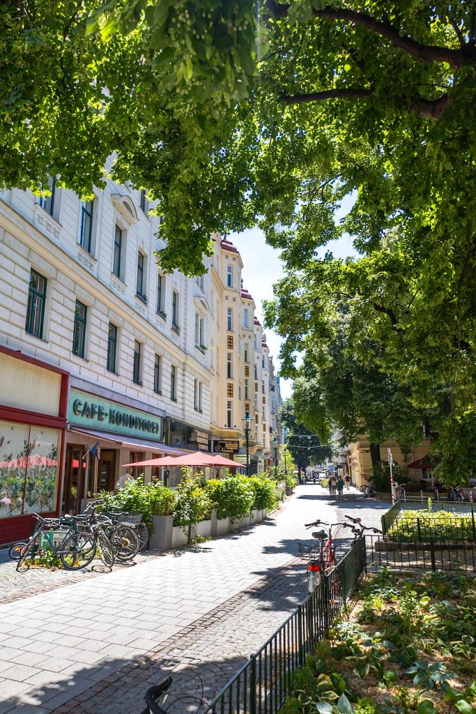 Servitengasse in Wien mit Geschäften und Bäumen.