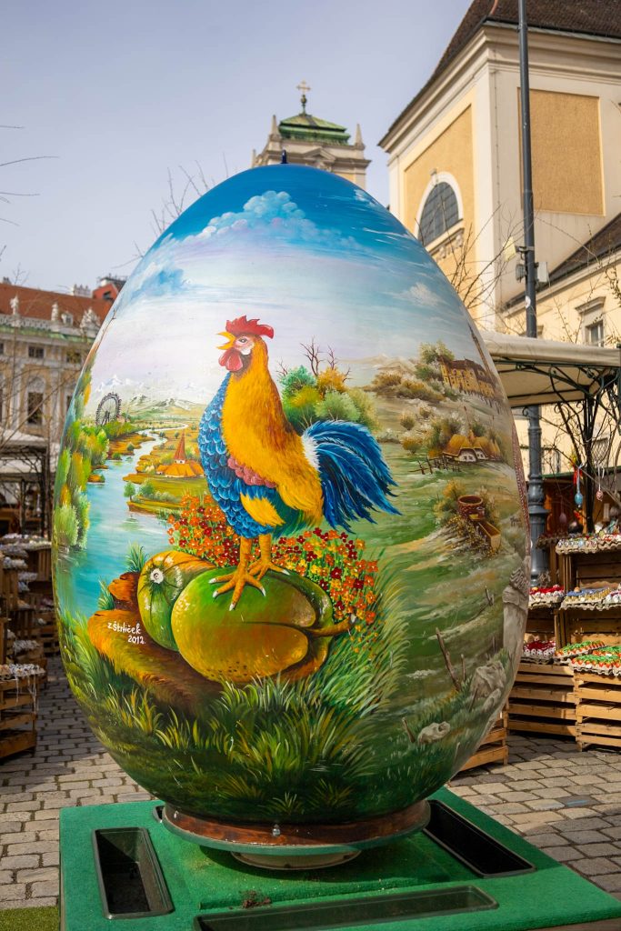 Riesiges Osterei bemalt mit einem bunten Bild eines Hahnes auf dem Ostermarkt auf der Freyung in Wien.