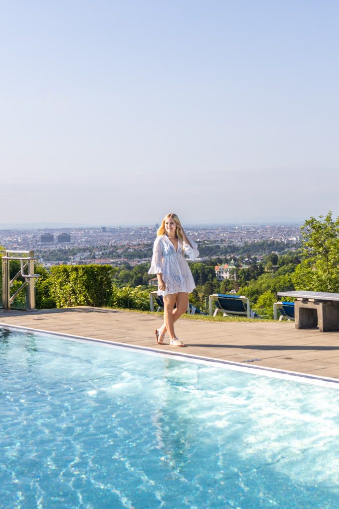 Pool im Krapfenwaldbad in Wien mit Blick auf die Stadt.