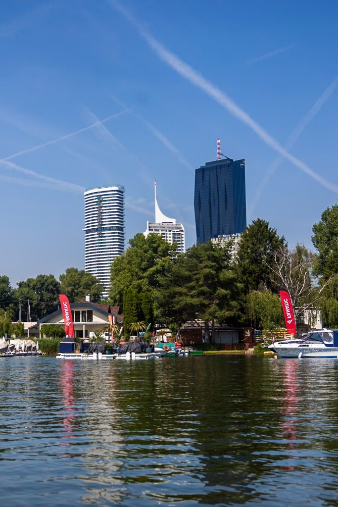 Bootfahrten auf der Alten Donau in Wien mit Blick auf Hochhäuser und Boote.
