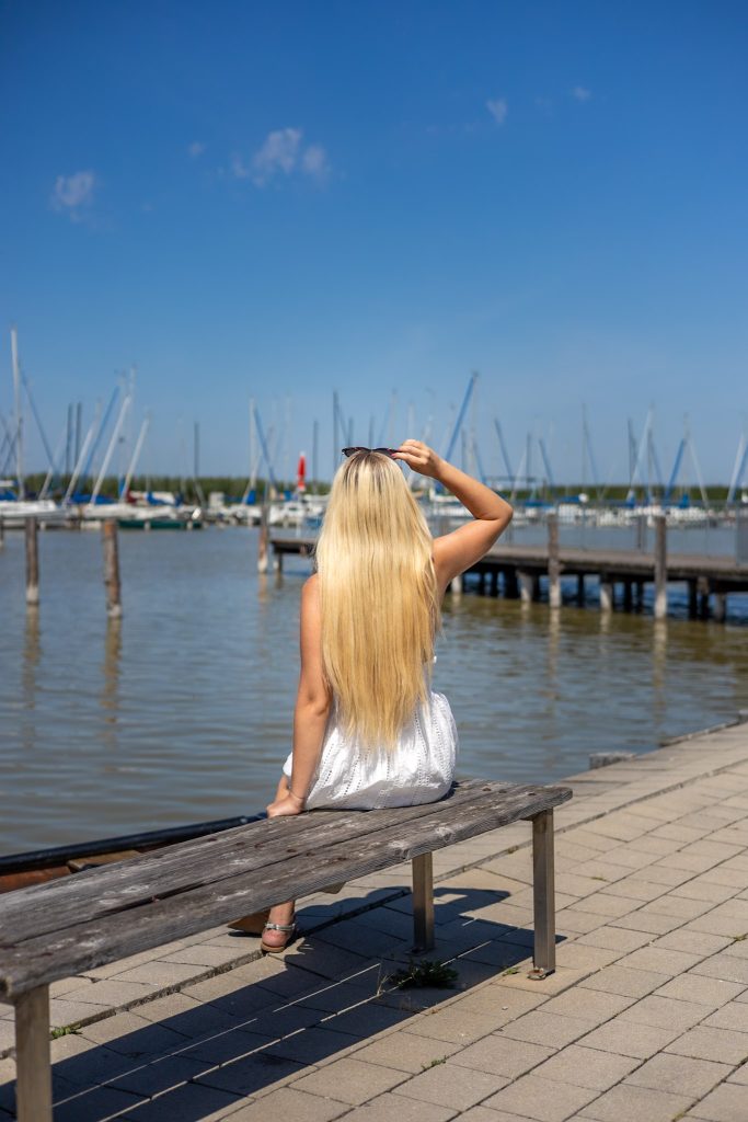 Bank auf der Promenade vor dem Strandbad in Rust am See im Burgenland mit Blick auf den See und die Segelboote.